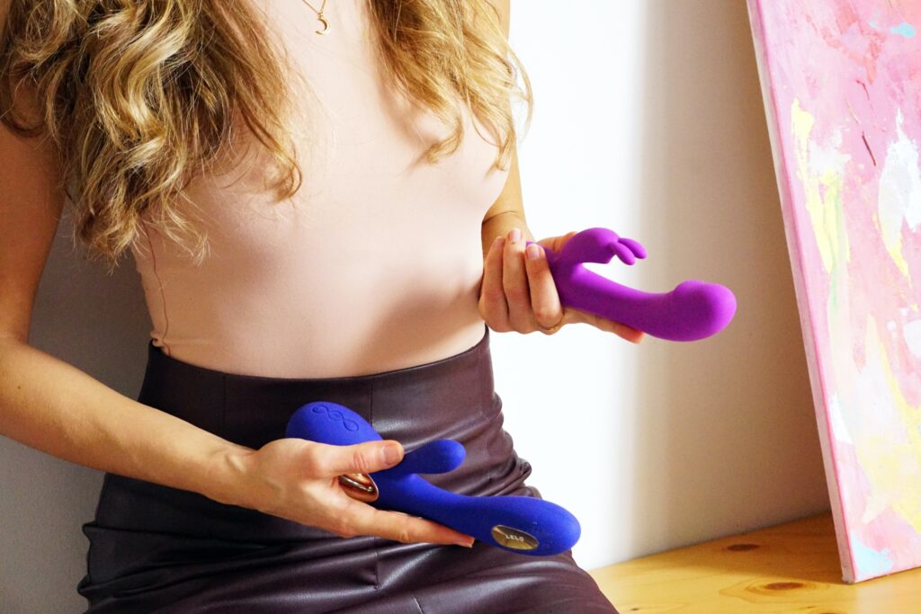Vrouw met twee vibrators in haar hand