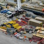 Overzicht van bouwplaats met gesorteerde duurzame materialen zoals hout, staal en kunststof elementen