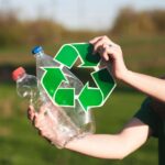 handen die flessen vasthouden en een recycle logo