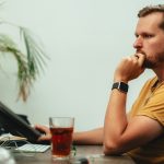 Man zit langdurig achter computer en kijkt geconcentreerd naar scherm, wat houding be&iuml;nvloedt