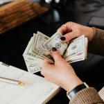 Accountant telt contant geld tijdens financi&euml;le analyse en budgetcontrole