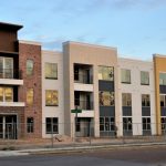 Deze tonen een modern nieuwbouwappartementencomplex met verschillende gevelmaterialen en ruime balkons.